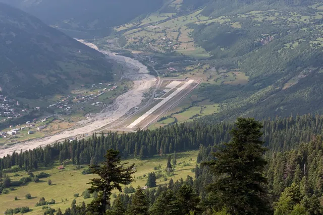 The runway of Queen Tamar Airport in Mestia among Svan towers and mountains