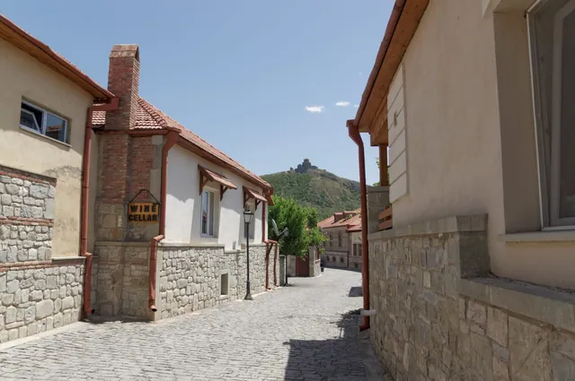A cobbled lane in Mtskheta's old town, with Jvari Monastery on the hill above