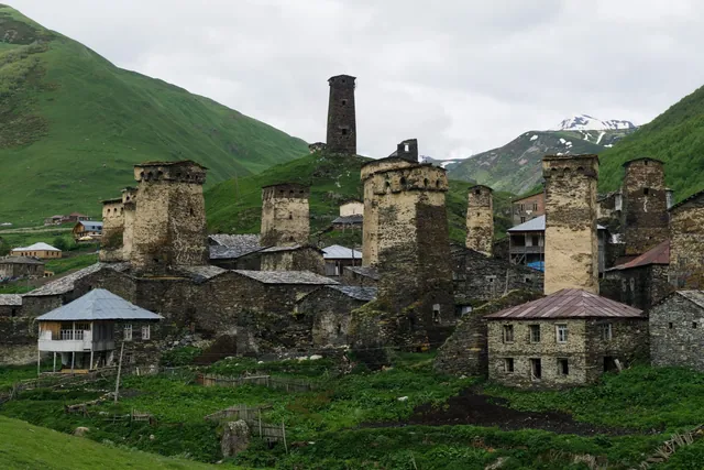 Svan towers of Ushguli among stone houses on a green slope